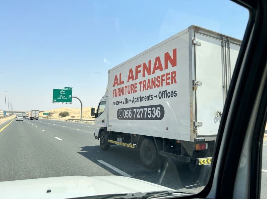 Al Afnan moving crew preparing wrapped furniture and boxes for a move between emirates