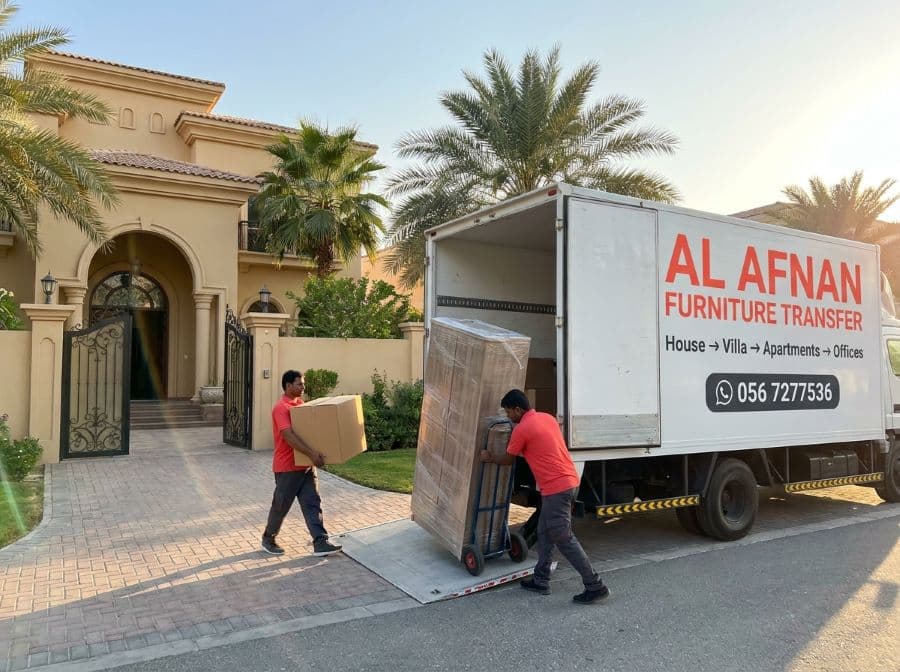 Al Afnan villa movers loading wrapped furniture into a truck outside a villa